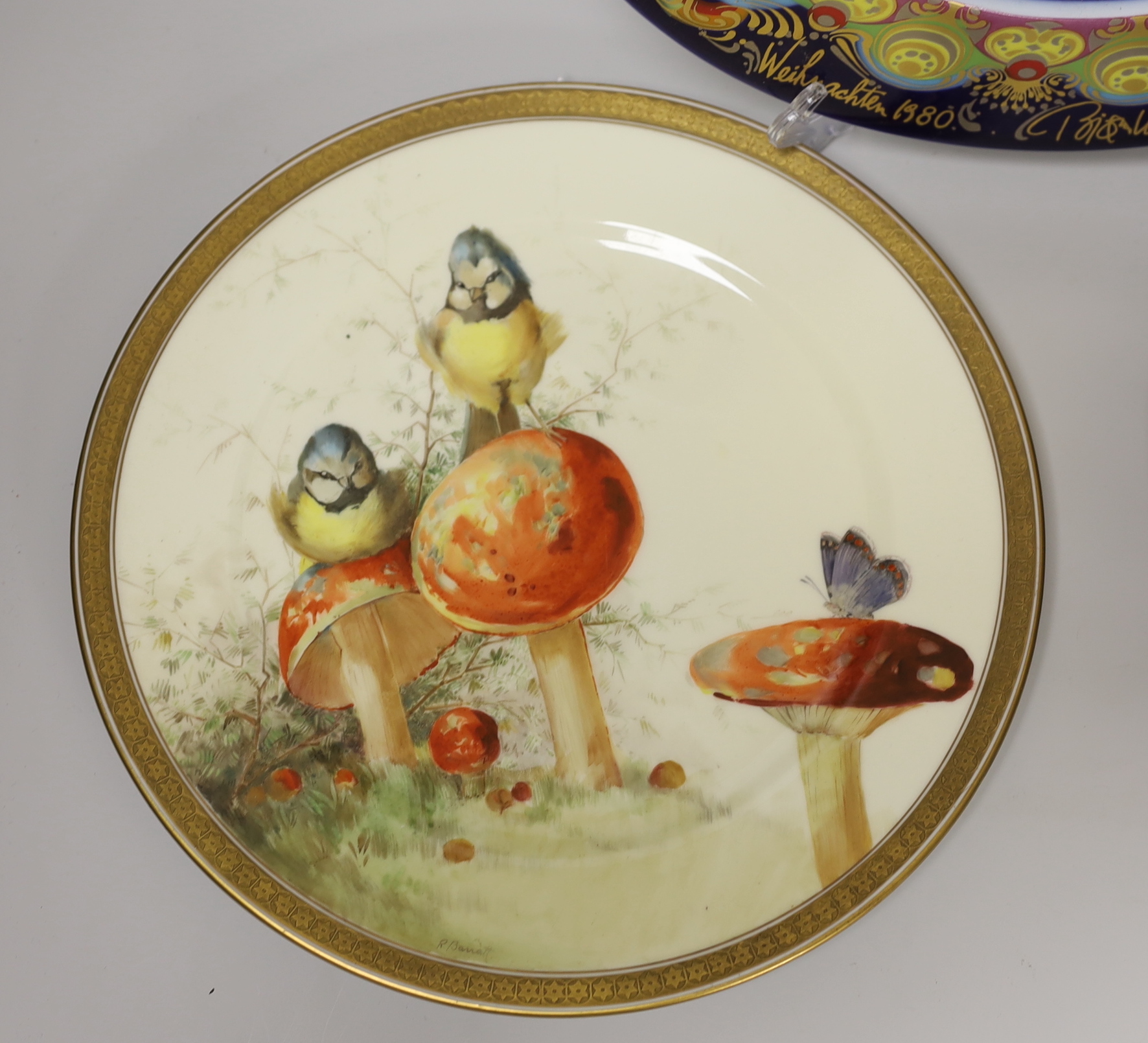 A Cauldon plate painted with blue tits on toadstools and a butterfly on another, signed R. Barratt, Derby, made for Burley & Co. Chicago, a Rosenthal limited edition plate Weihnachtsteller 1980, and an art pottery dish